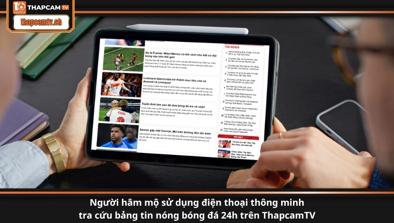 Người hâm mộ sử dụng điện thoại thông minh tra cứu bảng tin nóng bóng đá 24h trên ThapcamTV